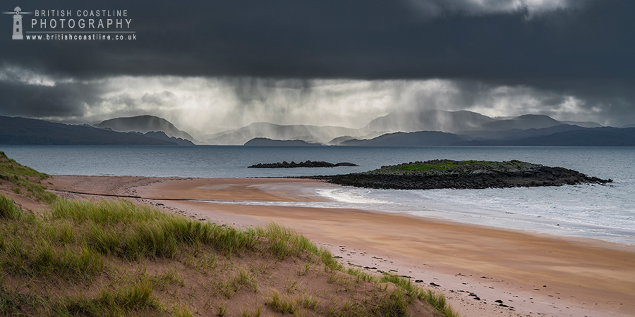 red point beach with mountainous backdrop and stormy weather