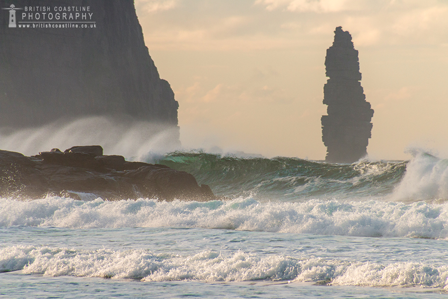 Sandwood Bay, crashing waves with sea spray, tall sea stack, sea cliffs, golden light